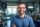 Handsome hispanic Wearing Glasses and a Dark Blue Shirt Smiling and Looking at Camera. Young South Asian Man Working as Engineer or Scientist in Technology Research Facility. AI Generative